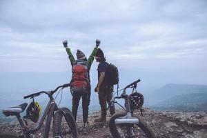 asiatische Liebhaberfrauen und -männer reisen Natur. Reisen entspannen Fahrrad fahren Wildnis in der Wildnis. steht auf einer felsigen Klippe. Thailand foto