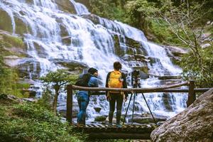 Paare reisen entspannt, um die schönen Wasserfälle zu fotografieren. im Winter. am wasserfall mae ya chiangmai in thailand. Natur reisen. Sommer foto