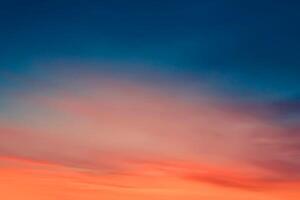 brillant orange Sonnenuntergang und Sonnenaufgang wunderschön über dunkelblauen Wolken mit leuchtend oranger Sonne an einem kühlen Frühlingsmorgen. foto