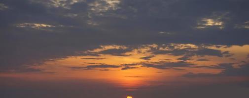 schöne orange himmel abendschönheit und wolken bei sonnenuntergang, dämmerung, die strahlen der sonne brechen durch die wolken. natürlich foto