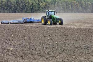 Traktor auf dem Feld bearbeitet den Boden nach der Ernte. foto