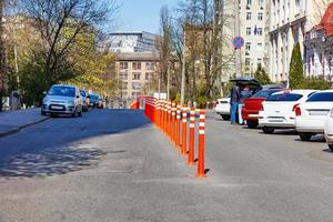 Orangefarbene Straßensäulen halbieren die Fahrbahn im sonnigen Frühlingstag. foto