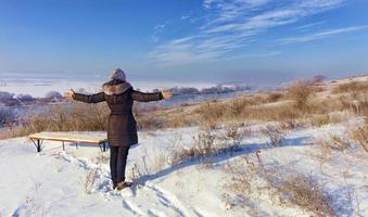 Eine junge Frau blickt an einem sonnigen Wintertag auf den ausgehenden Southern Bug River in die Ferne. foto