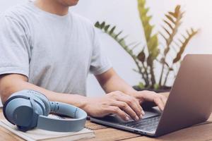 junger Mann mit Laptop auf Tastatur tippen foto