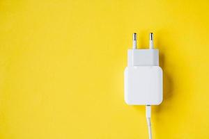 Handy-Ladegerät und USB-Kabel auf gelbem Hintergrund foto