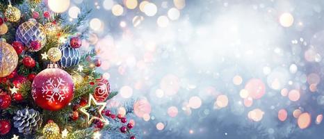 Weihnachtsbaum mit Ornament und Bokeh-Lichtern im verschneiten Hintergrund foto