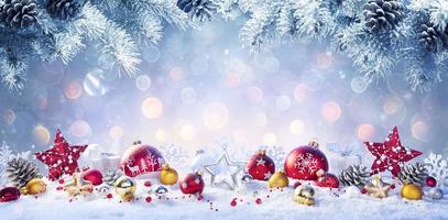Weihnachten - rote und goldene Kugeln auf Schnee mit Tannenzweigen foto
