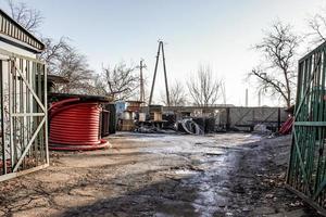 schmutziger Hof mit roten und schwarzen Plastikrohrrollen foto