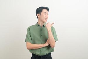 asiatischer Mann mit Hand zeigt oder präsentiert auf weißem Hintergrund foto