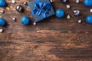 Weihnachtsblaue Geschenkbox und Silberkugeldekorationsverzierung auf Holztischhintergrund foto