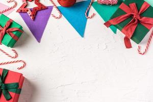 Draufsicht Weihnachten bunte Partyflagge und Geschenkbox auf weißem Paster Betontisch