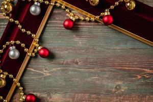 Weihnachtsdekoration Ornament Tiensel, Ball und roter Rahmen n Tisch Holz Hintergrund foto