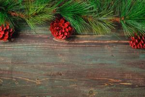 Weihnachtskiefertanne mit Tannenzapfendekoration auf rustikalem Holztischhintergrund der Weinlese foto