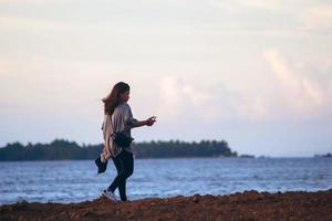 Sorong, West Papua, Indonesien 2021 - Mädchen allein am Strand in der Abenddämmerung. foto