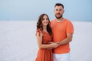 junges Paar in orangefarbener Kleidung mit Hund