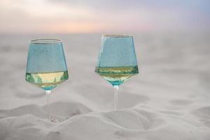 Hochzeitsbrille aus blauem Glas im Sand vergraben foto
