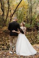 Spaziergang des Brautpaares durch den Herbstwald foto