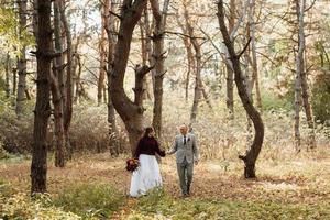 Spaziergang des Brautpaares durch den Herbstwald foto