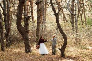 Spaziergang des Brautpaares durch den Herbstwald foto