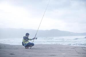 pacitan, indonesien 2021 - mann fischt an der küste foto