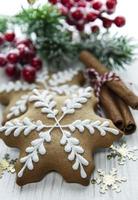 Weihnachtslebkuchen mit Weihnachtsschmuck auf weißem Holz foto