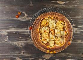 Birnen-Pfirsich-Torte mit Haselnusscreme, Haselnüssen und essbaren Blüten. französische Gourmetküche foto