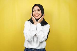 schöne junge asiatische muslimische frau, die selbstbewusst, enthusiastisch und fröhlich lächelt, mit den händen v zeichen am kinn einzeln auf gelbem hintergrund