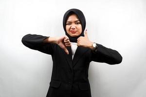 schöne asiatische junge muslimische Geschäftsfrau mit Handzeichen wie oder Abneigung, ja oder nein, glücklich oder traurig, zwei Dinge vergleichend, isoliert auf weißem Hintergrund