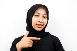Nahaufnahme einer schönen jungen muslimischen Frau, die auf den leeren Raum zeigt, isoliert foto