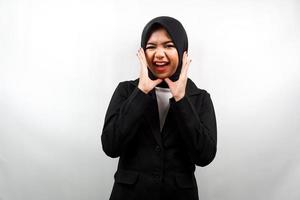 schöne junge asiatische muslimische Geschäftsfrau schockiert, überrascht, wow-Ausdruck, mit Händen, die Wange halten, isoliert auf weißem Hintergrund foto