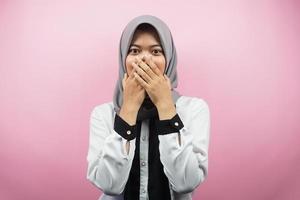 schöne junge asiatische muslimische frau schockiert, überrascht, ungläubig, bekommt schockierende informationen, mit den händen, die den mund einzeln auf rosa hintergrund bedecken foto