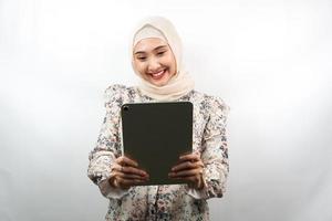 schöne junge asiatische muslimische Frau lächelnd, aufgeregt und fröhlich mit Tablet, isoliert auf weißem Hintergrund foto