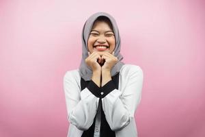 schöne junge asiatische muslimische frau, die glücklich lächelt, süß, sich wohl fühlt, sich umsorgt fühlt, sich gut fühlt, mit den händen, die das kinn einzeln auf rosa hintergrund halten