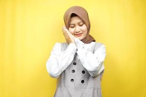 schöne asiatische junge muslimische frau, die friedlich schläft, sich wohl fühlt, sich glücklich fühlt, isoliert auf gelbem hintergrund