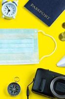 Reisepass, Notizblock und medizinische Maske auf blauem Hintergrund. foto