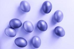 leuchtende Eier auf violettem Hintergrund. Frohe Ostern. Trendfarbe des Jahres 2022.