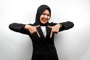 Schöne asiatische junge muslimische Geschäftsfrau mit nach unten zeigenden Händen, Hände klicken auf den untenstehenden Link, Hände, die etwas präsentieren, isoliert auf weißem Hintergrund foto
