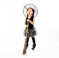 Portrait asiatisches kleines Mädchen in süßer Hexe für Halloween-Kostüm mit Besen foto