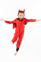 Porträt asiatisches kleines süßes Mädchen im bösen Kostüm für Halloween-Festival mit Kürbis foto