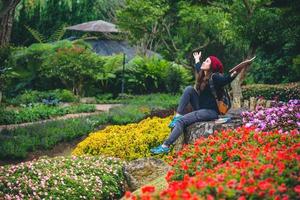 Frau reisen Natur im Blumengarten. Entspannen Sie auf Felsen sitzen und Bücher lesen inmitten der Natur im Nationalpark Doi Inthanon. foto