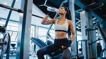 schöne junge asiatische dame übung trinkwasser nach fettverbrennungstraining im fitnesskurs. Sportler mit Sixpack, Sportler-Freizeitaktivität, funktionelles Training, gesundes Lifestyle-Konzept. foto