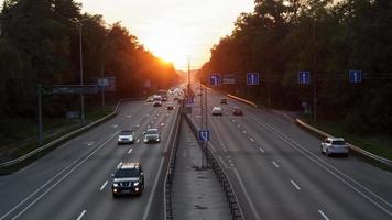 fahrende Autos auf der Autobahn bei Sonnenuntergang. Autobahnverkehr bei Sonnenuntergang mit Autos. viel Verkehr auf der Autobahn, Straßenansicht von oben. foto