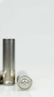 Aa Alkaline-Akkus auf weißem glänzendem Hintergrund mit Reflektion. Schließen Sie zwei leere Batterien mit Kopienraum. vertikale Fotografie. foto