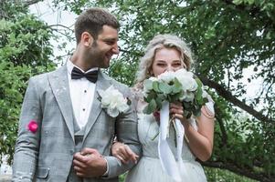 Braut und Bräutigam bei der Hochzeitszeremonie. Gratulation der Gäste. Duschen mit Rosenblättern. selektiver Fokus. Filmkorn. foto