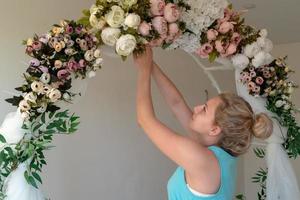 Mädchen macht Hochzeit, festlicher Blumenbogen foto