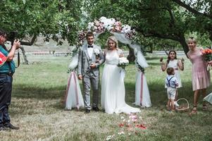 Braut und Bräutigam bei der Hochzeitszeremonie. Gratulation der Gäste. Duschen mit Rosenblättern. selektiver Fokus. Filmkorn. foto