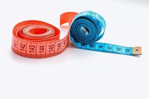 Zentimeterband rosa und blau auf weißem Hintergrund. das Konzept der Gewichtsabnahme und eines gesunden Lebensstils. foto
