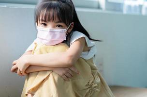 asiatisches Kind mit Maske zu Hause foto