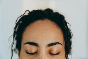 Schwarze Frau posiert mit geschlossenen Augen während der Zeit zu Hause foto