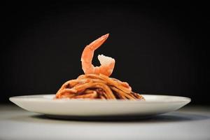 Spaghetti Bolognese italienische Pasta mit Garnelen auf weißem Teller mit schwarzem Hintergrund serviert - italienisches Essen und Menükonzept Spaghetti Meeresfrüchte foto